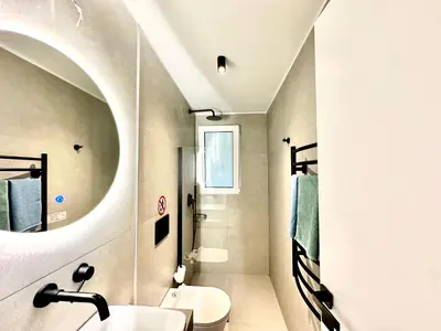 a bathroom with a sink and a toilet and a mirror at Urban Calm Glyfada Getaway 2BD in Athens