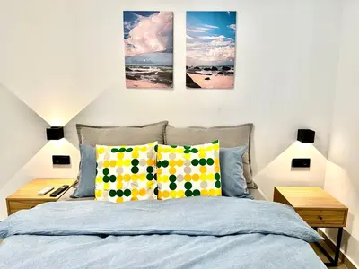 a bedroom with a bed with three paintings on the wall at Urban Calm Glyfada Getaway 2BD in Athens