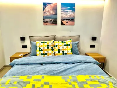 a bedroom with a bed with three paintings on the wall at Urban Calm Glyfada Getaway 2BD in Athens