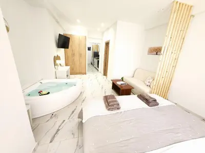 a bathroom with a tub and a bed in it at Lux Suite Jacuzzi Acropolis byMK in Athens