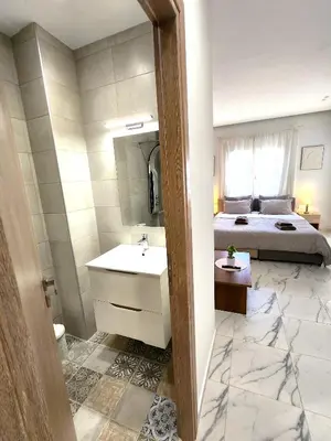 a bathroom with a sink and a bedroom with a bed at Lux Suite Jacuzzi Acropolis byMK in Athens