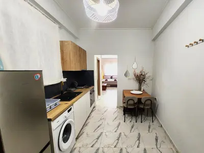 a kitchen with a small table and a kitchen with a refrigerator at Lux Suite Jacuzzi Acropolis byMK in Athens