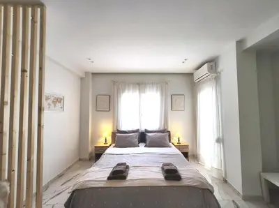a large bed in a room with two windows at Lux Suite Jacuzzi Acropolis byMK in Athens