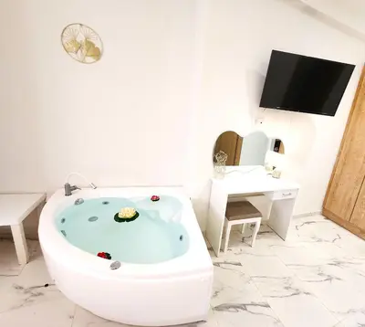 a bathroom with a bath tub with a tv on the wall at Lux Suite Jacuzzi Acropolis byMK in Athens