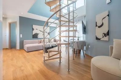 a spiral staircase in a living room with a table at AURA Gazi apartments in Athens
