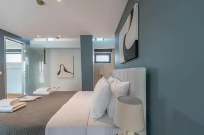 a bedroom with a large bed with white pillows at AURA Gazi apartments in Athens