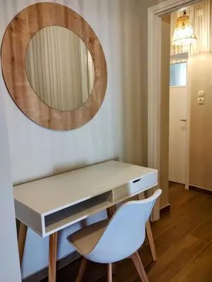 a dressing table with a mirror and a white chair at Dita's Cozy Stay in Athens