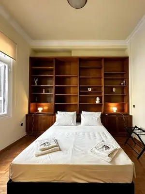 a bedroom with a large bed with wooden shelves at Sis Urban,Timeless Elegance in Athens
