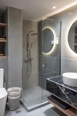 a bathroom with a glass shower and a toilet at Never Space Up Apartment in Piraeus