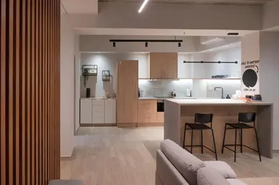 a kitchen and living room with a couch and a counter at Never Space Up Apartment in Piraeus