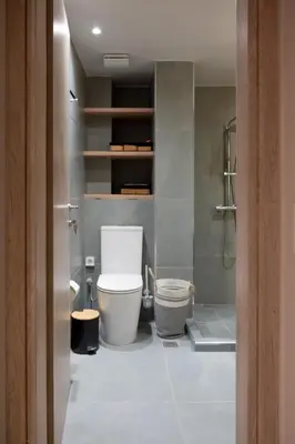 a bathroom with a white toilet and a shower at Never Space Up Apartment in Piraeus