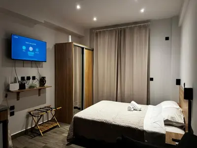 a bedroom with a bed and a tv on the wall at Platon Loft in Athens