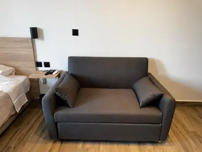 a couch sitting in a room next to a bed at Platon Loft in Athens
