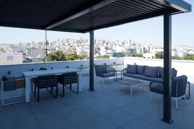 a patio with a couch and chairs and a table at Loft Garden of Port in Piraeus in Piraeus