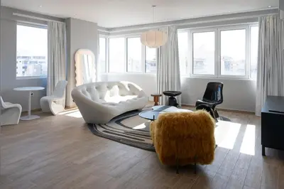a living room with a white couch and a chair at Loft Garden of Port in Piraeus in Piraeus