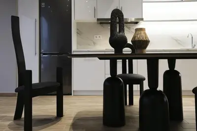 a black dining room table with two black chairs at Loft Garden of Port in Piraeus in Piraeus