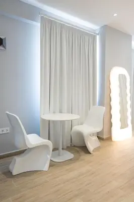 a room with white chairs and a table and a table and chairs at Loft Garden of Port in Piraeus in Piraeus