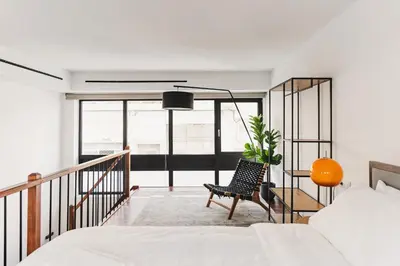 a bedroom with a bed and a chair and a balcony at Ella Luxury Suites in Athens