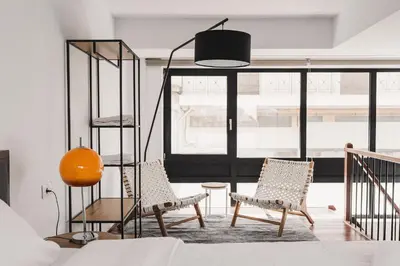 a living room with two chairs and a lamp at Ella Luxury Suites in Athens