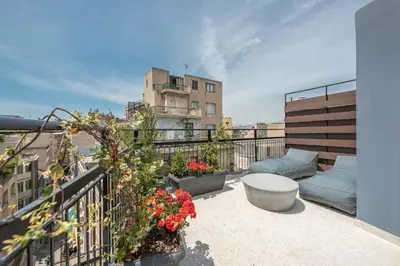 a balcony with a couch and flowers on a building at Huge Balcony Penthouse in City Center - Zen Asteria in Athens