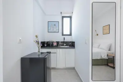 a small white kitchen with a sink and a bed at Huge Balcony Penthouse in City Center - Zen Asteria in Athens