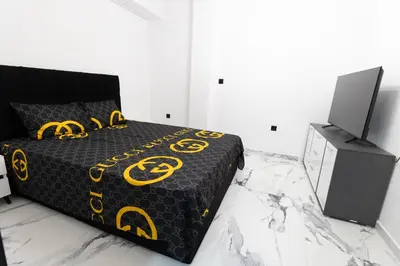a bedroom with a bed with a black and yellow comforter at Apartment with jacuzzi and sauna in Athens