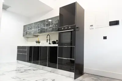 a kitchen with black cabinets and a counter at Apartment with jacuzzi and sauna in Athens