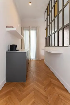 a kitchen with white walls and a wooden floor at Kismet Urban Stay in Athens