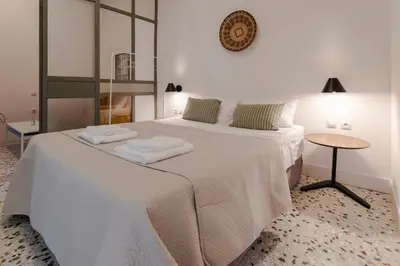 a bedroom with a white bed with two towels on it at Kismet Urban Stay in Athens
