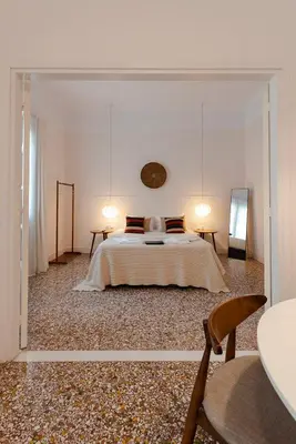 a white bedroom with a bed and two tables at Kismet Urban Stay in Athens