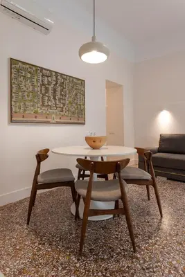a dining room with a table and chairs and a couch at Kismet Urban Stay in Athens