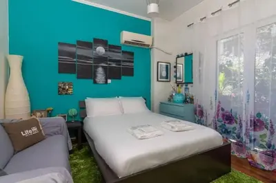 a bedroom with a white bed and a blue wall at Casa Di Fiori Pireas in Piraeus