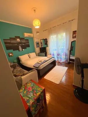 a bedroom with two beds and a living room at Casa Di Fiori Pireas in Piraeus