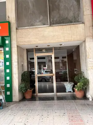 a store front with a glass door and two potted plants at Casa Di Fiori Pireas in Piraeus