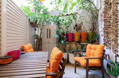 a patio with two chairs and a table with plants at Casa Di Fiori Pireas in Piraeus