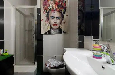 a bathroom with a sink and a painting of a woman at Casa Di Fiori Pireas in Piraeus