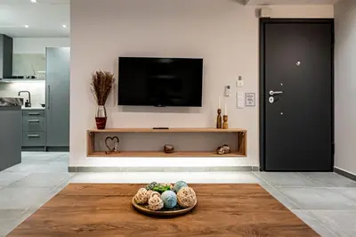 a living room with a television and a bowl of eggs at Wooden Style Apartment in Piraeus in Piraeus
