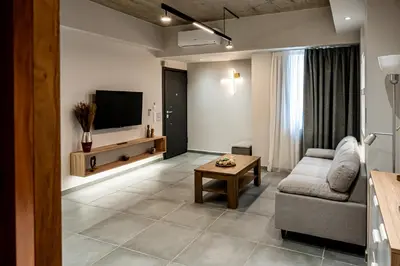 a living room with a couch and a tv at Wooden Style Apartment in Piraeus in Piraeus
