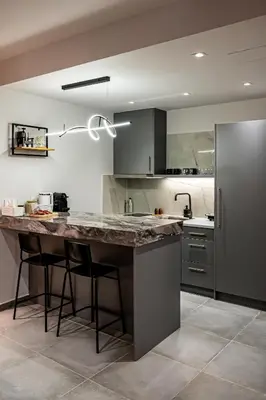 a kitchen with a large counter and a refrigerator at Wooden Style Apartment in Piraeus in Piraeus