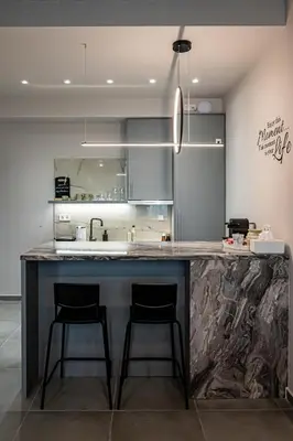 a kitchen with a large counter with two bar stools at Vintage Road Apartment in Piraeus in Piraeus