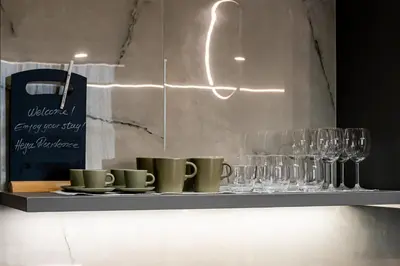 a shelf with cups and wine glasses on it at Vintage Road Apartment in Piraeus in Piraeus