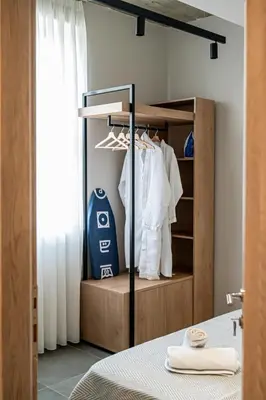 a bedroom with a closet with white clothes and a window at Vintage Road Apartment in Piraeus in Piraeus