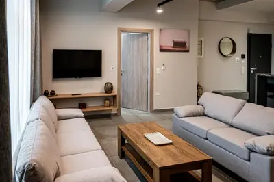 a living room with two couches and a tv at Vintage Road Apartment in Piraeus in Piraeus