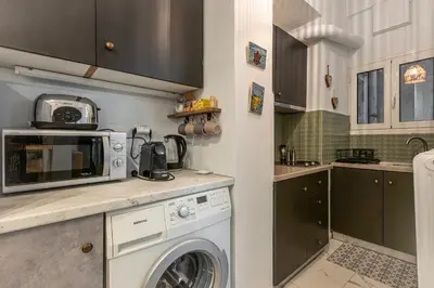 a kitchen with a washing machine and a microwave at Cozy Apartment in Exarchia, Walk to Athens Museum in Athens