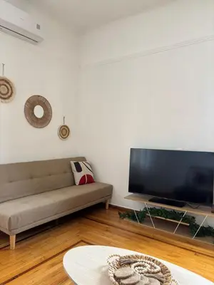 a living room with a couch and a flat screen tv at Plaka's Central, Cozy and Comfort Home in Athens