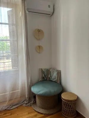 a room with a green chair and a window at Plaka's Central, Cozy and Comfort Home in Athens