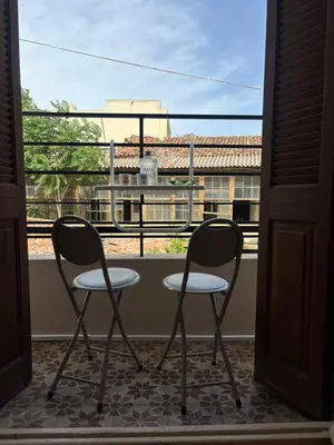 two chairs on a balcony with a view of a building at Plaka's Central, Cozy and Comfort Home in Athens