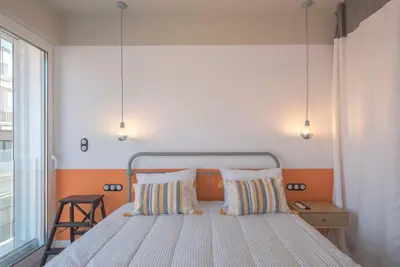 a bedroom with a bed with two pillows and a window at Charming apartment on Athens most famous street in Athens