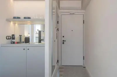a kitchen with white cabinets and a white door at Charming apartment on Athens most famous street in Athens