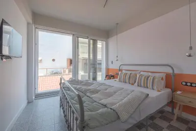 a bedroom with a bed and a large window at Charming apartment on Athens most famous street in Athens